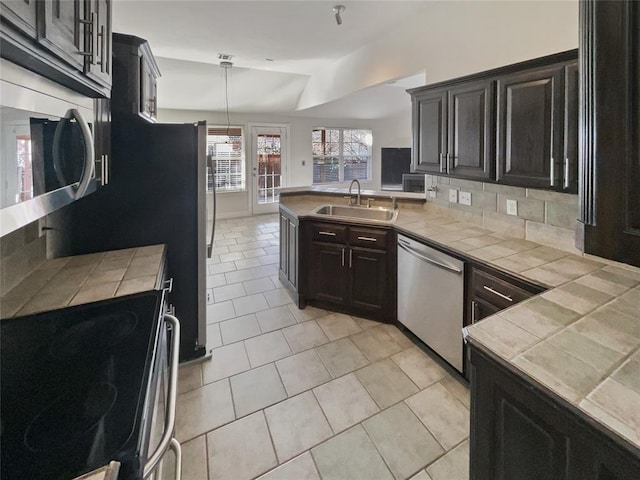 kitchen featuring decorative light fixtures, stainless steel appliances, tile counters, and sink