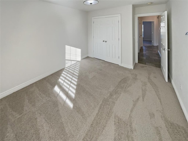 unfurnished bedroom featuring light carpet and a closet