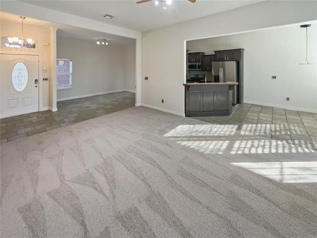 unfurnished living room featuring light carpet and ceiling fan with notable chandelier