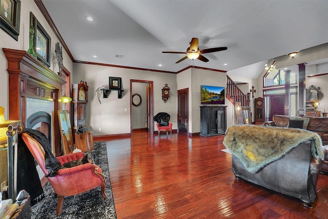 living room with lofted ceiling, ornamental molding, hardwood / wood-style flooring, ceiling fan, and a fireplace