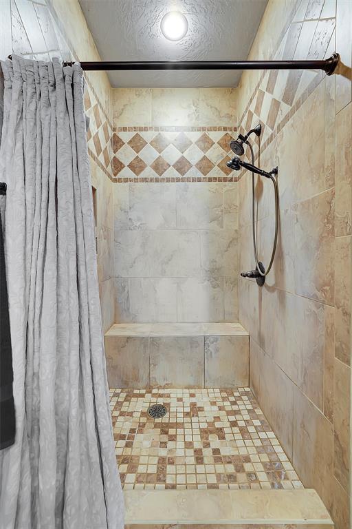 bathroom featuring a shower with curtain and a textured ceiling