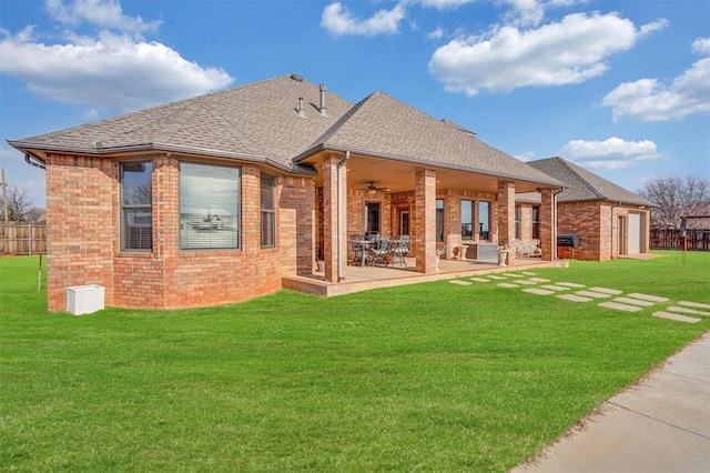 rear view of property with a patio, a yard, and ceiling fan