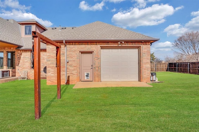 rear view of property with a garage and a yard