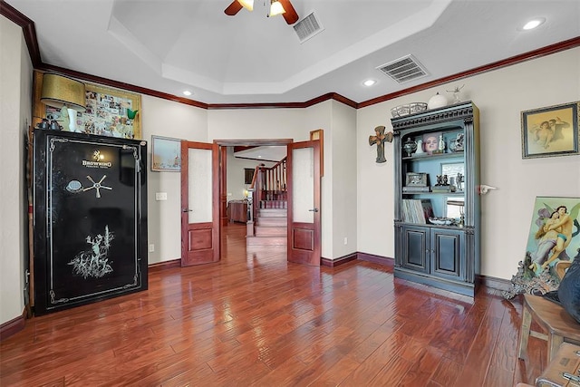 interior space with ceiling fan, ornamental molding, a tray ceiling, and hardwood / wood-style floors