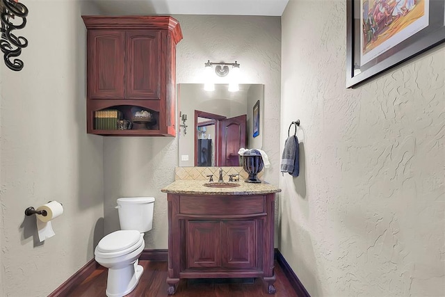 bathroom with vanity, hardwood / wood-style flooring, decorative backsplash, and toilet