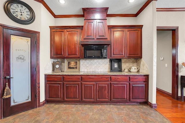 kitchen with crown molding, light stone countertops, backsplash, and black appliances