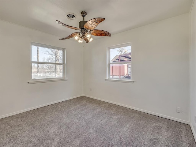 carpeted spare room featuring ceiling fan and a healthy amount of sunlight