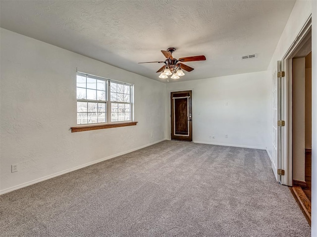 carpeted spare room featuring ceiling fan and a textured ceiling