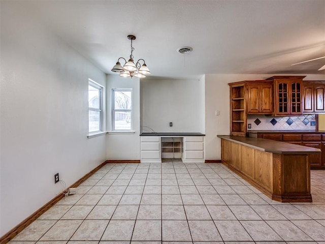 kitchen with backsplash, kitchen peninsula, light tile patterned floors, and hanging light fixtures