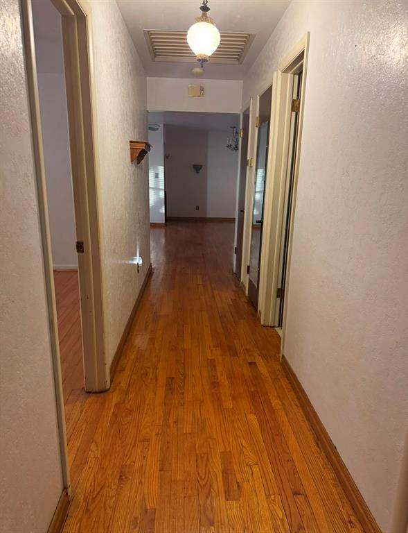 corridor with hardwood / wood-style floors