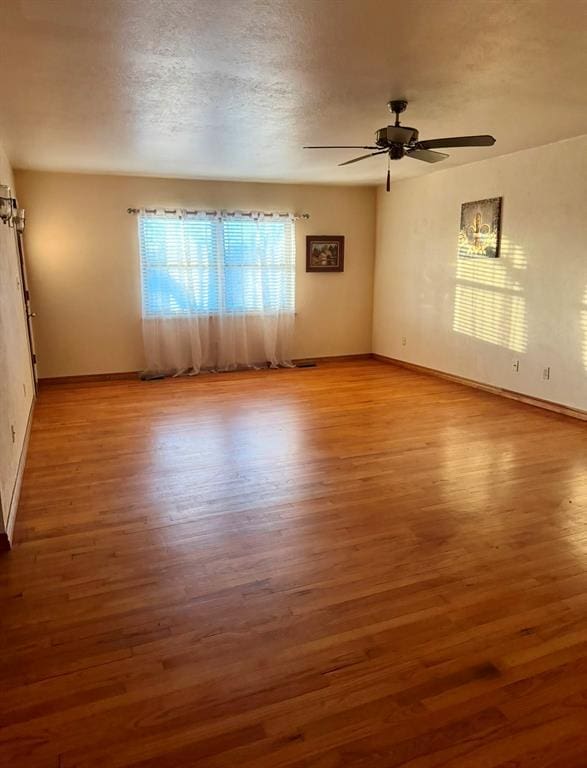 unfurnished room featuring ceiling fan, wood-type flooring, and a textured ceiling