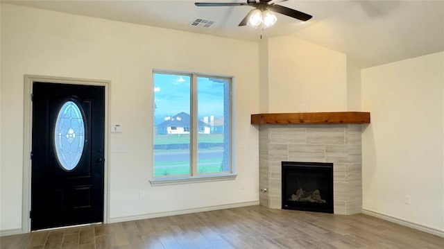 entryway featuring ceiling fan, plenty of natural light, light wood-type flooring, and a fireplace