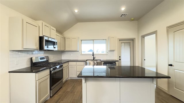 kitchen with a kitchen island, sink, white cabinetry, and stainless steel appliances