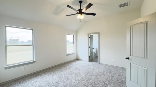 unfurnished bedroom featuring ceiling fan, light colored carpet, lofted ceiling, and connected bathroom