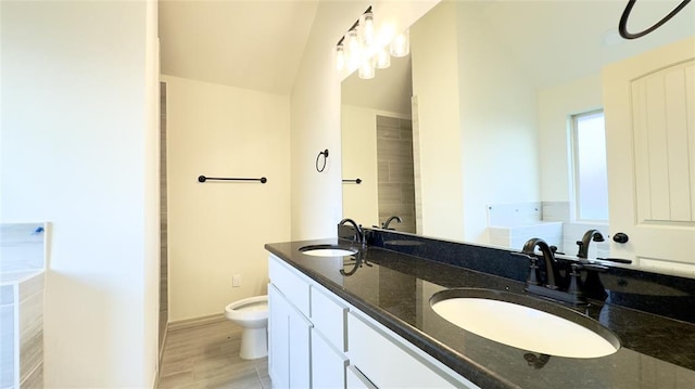 bathroom featuring hardwood / wood-style flooring, vanity, toilet, and a bath