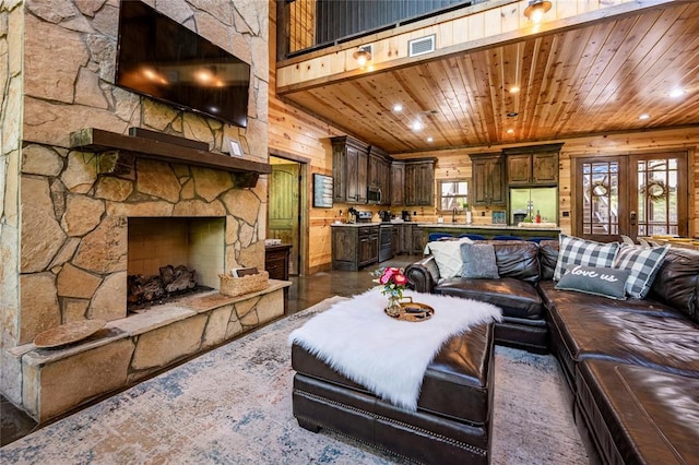 living room featuring french doors, wood ceiling, wood walls, and sink