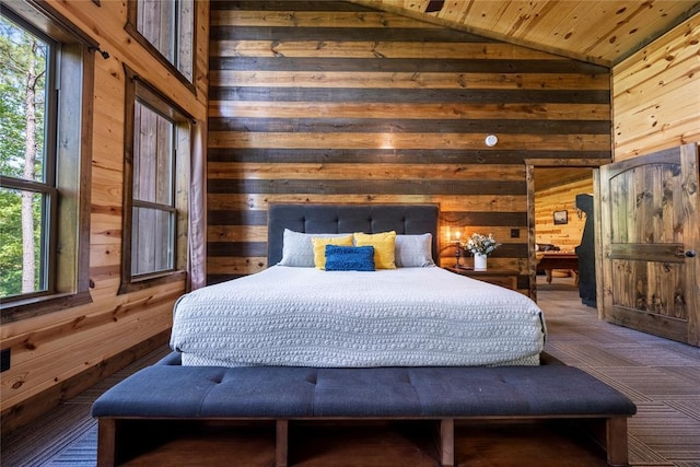 bedroom with multiple windows, wood walls, and vaulted ceiling