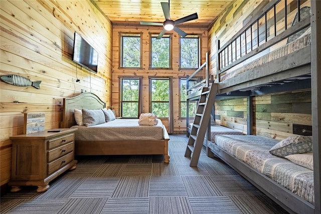 carpeted bedroom featuring access to outside, multiple windows, wood walls, and wood ceiling