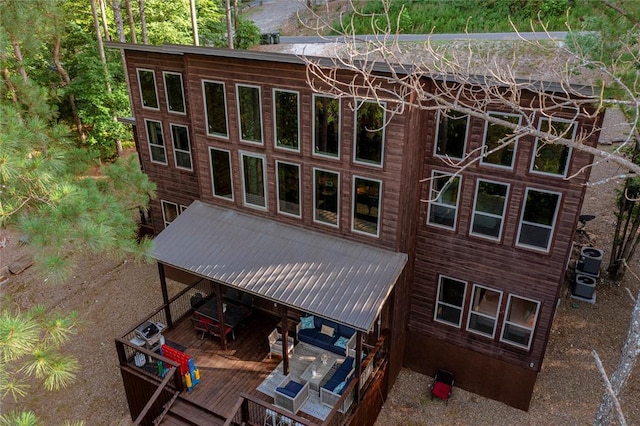 rear view of property featuring central AC unit and a wooden deck