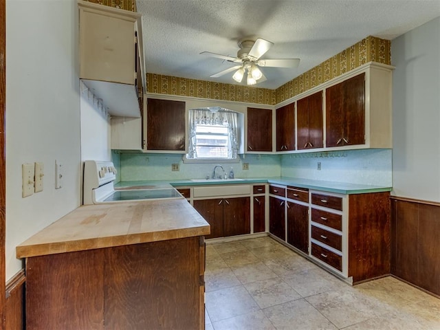 kitchen featuring ceiling fan, dark brown cabinets, a textured ceiling, and range