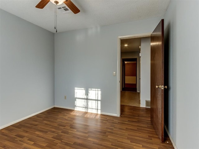 spare room with ceiling fan, dark wood-type flooring, and a textured ceiling