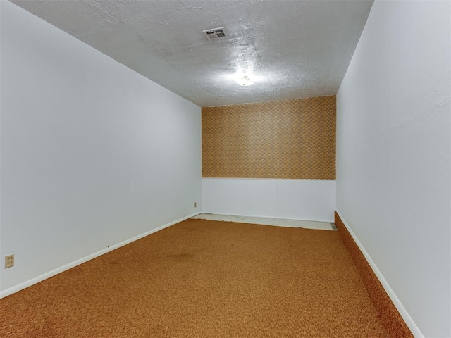 carpeted spare room featuring a textured ceiling