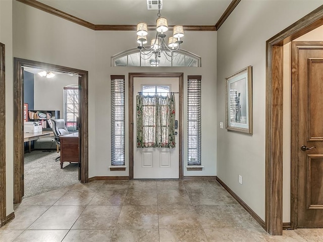 carpeted foyer with an inviting chandelier and crown molding