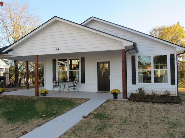 view of front of house with covered porch and a front yard