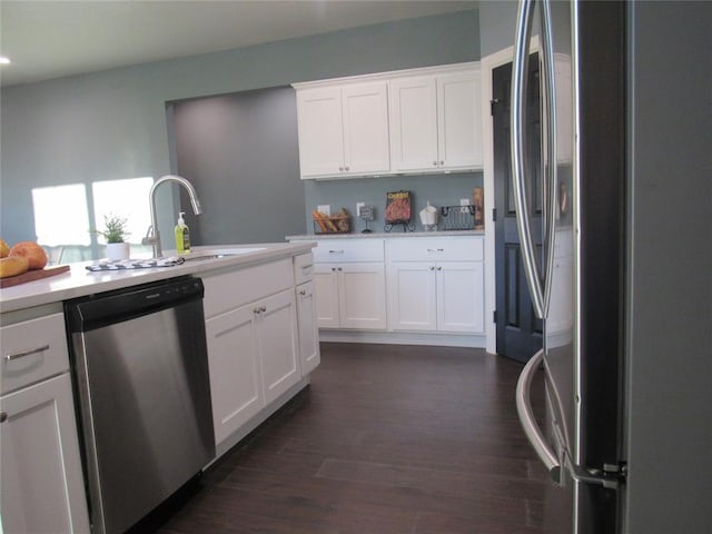 kitchen with dark wood finished floors, stainless steel appliances, light countertops, and a sink