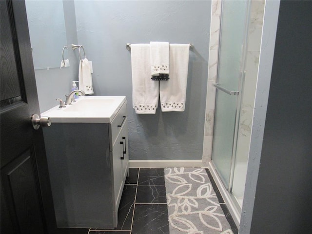 bathroom with vanity, a shower stall, baseboards, and marble finish floor