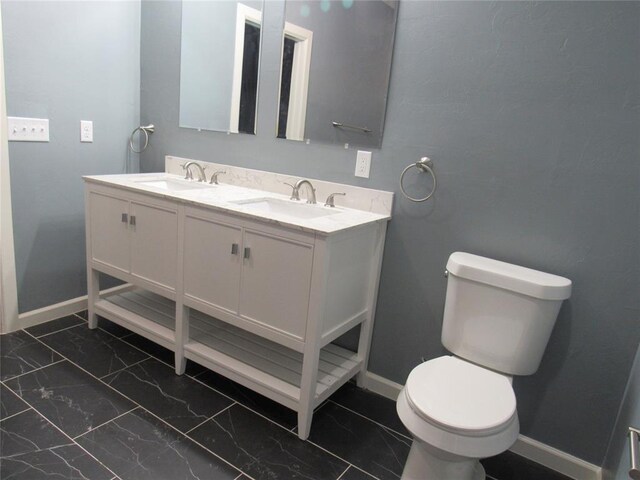 bathroom with a sink, baseboards, toilet, and marble finish floor