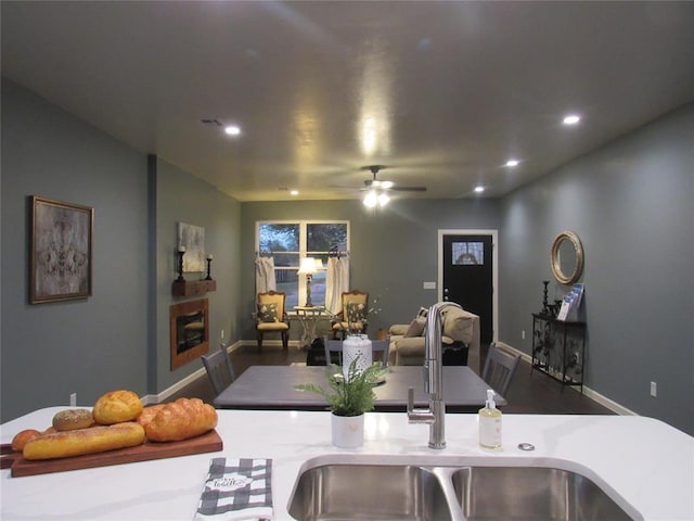 kitchen with sink, a fireplace, and ceiling fan