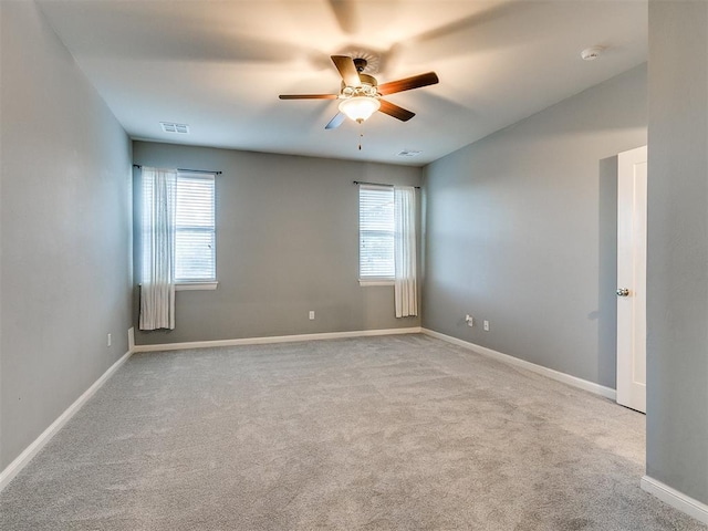 unfurnished room with light colored carpet and ceiling fan