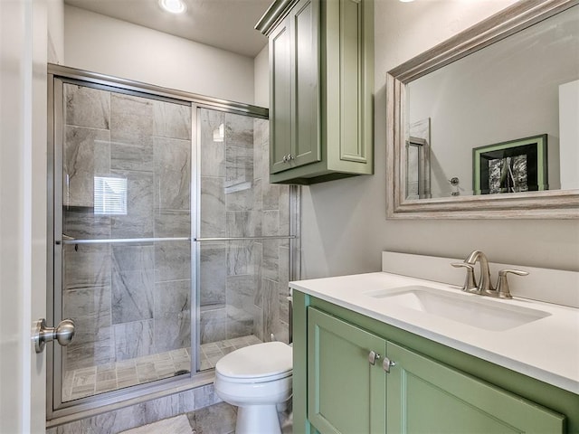 bathroom with a shower with door, vanity, and toilet