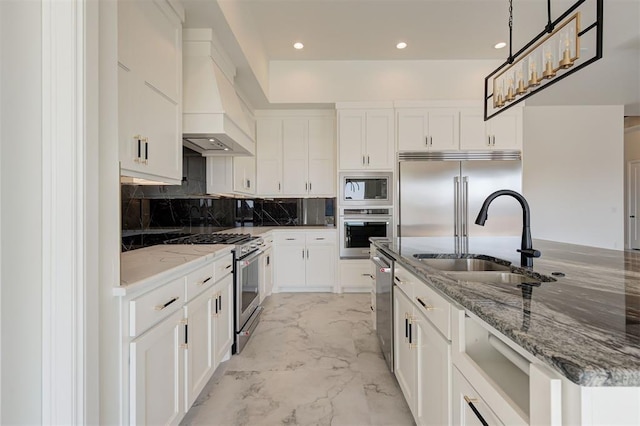 kitchen featuring sink, built in appliances, white cabinets, and custom range hood