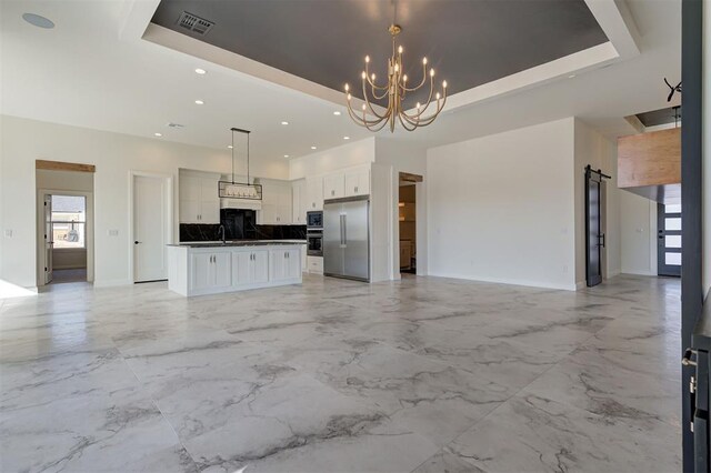 2270 NW 227th St, Edmond, OK 73025 - unfurnished living room with a raised ceiling, visible vents, baseboards, and a notable chandelier
