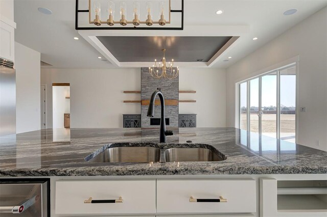 2270 NW 227th St, Edmond, OK 73025 - kitchen featuring open floor plan, a sink, dark stone countertops, and an inviting chandelier