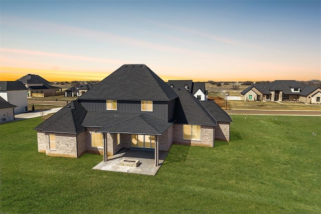 2270 NW 227th St, Edmond, OK 73025 - rear view of property with board and batten siding, a lawn, a shingled roof, and a patio