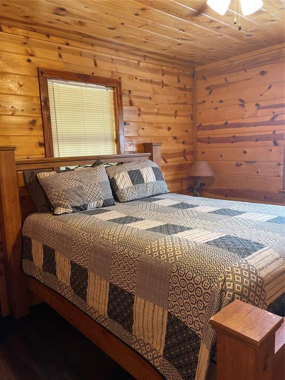 bedroom featuring wooden walls and wood ceiling