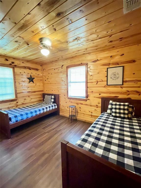 bedroom featuring wood walls, hardwood / wood-style floors, and wood ceiling