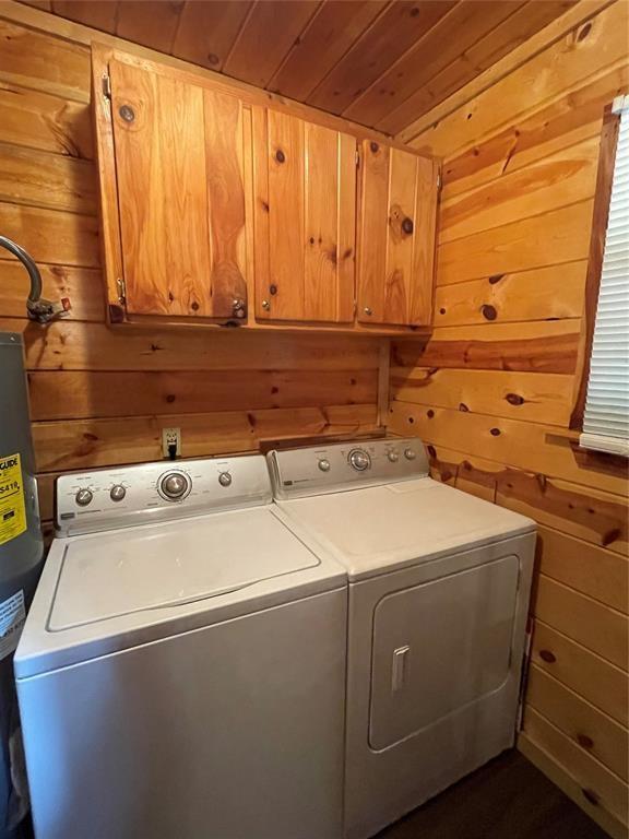 laundry area featuring washer and dryer, wood walls, cabinets, and wood ceiling