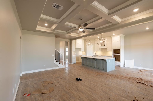 16024 Coneflower Dr, Edmond, OK 73013 - unfurnished living room with coffered ceiling, a sink, baseboards, beam ceiling, and a ceiling fan