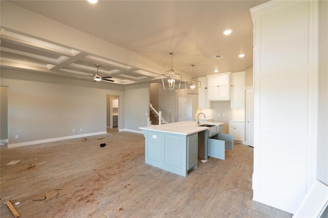 16024 Coneflower Dr, Edmond, OK 73013 - kitchen with coffered ceiling, light wood-style flooring, recessed lighting, white cabinetry, and baseboards
