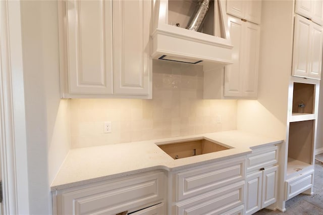 16024 Coneflower Dr, Edmond, OK 73013 - kitchen with white cabinetry, backsplash, light stone counters, and custom exhaust hood