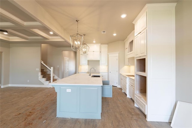 16024 Coneflower Dr, Edmond, OK 73013 - kitchen with a sink, a kitchen island with sink, recessed lighting, light wood-style flooring, and white cabinets