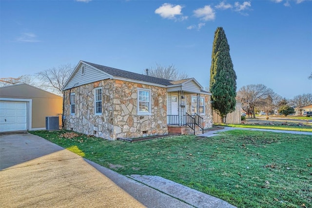 single story home with a garage, central air condition unit, an outbuilding, and a front yard