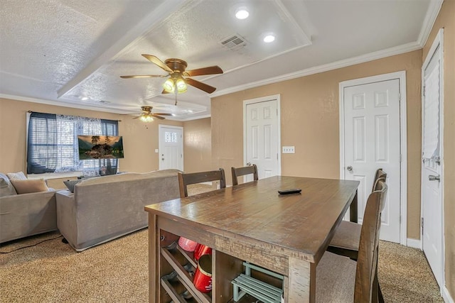 dining room with a textured ceiling, ceiling fan, ornamental molding, and light carpet