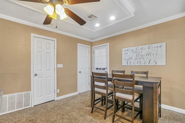 carpeted dining space with crown molding and ceiling fan