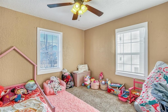 carpeted bedroom featuring ceiling fan and a textured ceiling