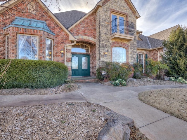 view of front of property with a balcony and french doors